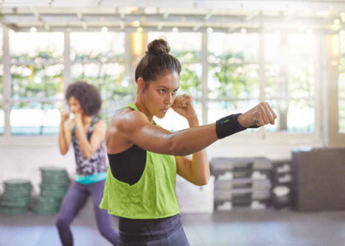 Mujer utilizando la muñequera para tendinitis Actimove Sports Edition durante la práctica deportiva. Mujer utilizando la muñequera para tendinitis Actimove Sports Edition durante la práctica deportiva.